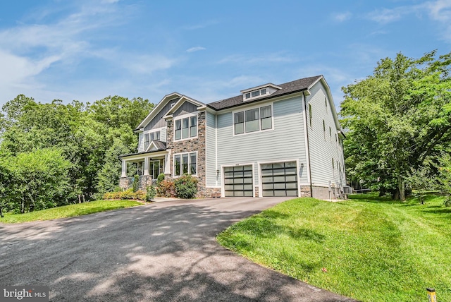 9908 Blake Ln, Oakton, VA 22124 - craftsman inspired home with asphalt driveway, stone siding, an attached garage, and a front lawn