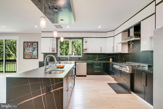 9908 Blake Ln, Oakton, VA 22124 - kitchen featuring wall chimney exhaust hood, appliances with stainless steel finishes, light wood finished floors, white cabinets, and recessed lighting