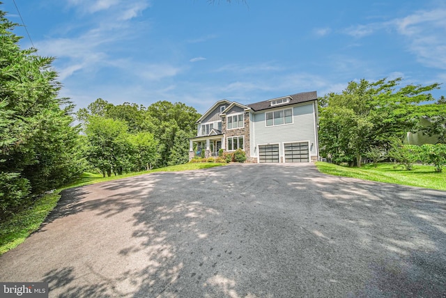9908 Blake Ln, Oakton, VA 22124 - view of front facade featuring asphalt driveway, stone siding, and a garage