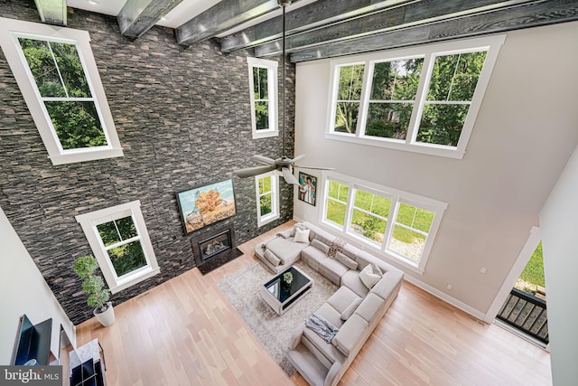 9908 Blake Ln, Oakton, VA 22124 - living area with wood finished floors, a high ceiling, a ceiling fan, a glass covered fireplace, and beamed ceiling