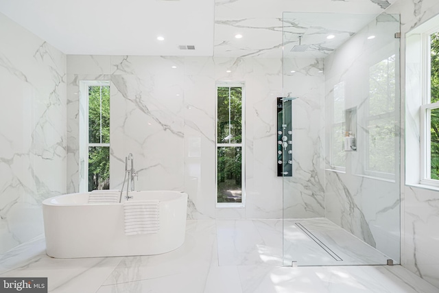 9908 Blake Ln, Oakton, VA 22124 - full bath with a soaking tub, plenty of natural light, a marble finish shower, and stone wall