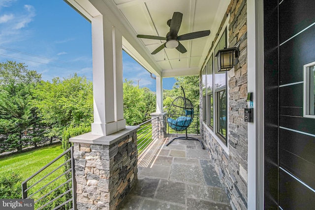 9908 Blake Ln, Oakton, VA 22124 - covered porch with a ceiling fan and view of wooded area