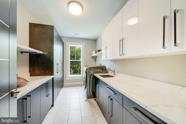 9908 Blake Ln, Oakton, VA 22124 - laundry room with washer and clothes dryer, light marble finish flooring, and cabinet space
