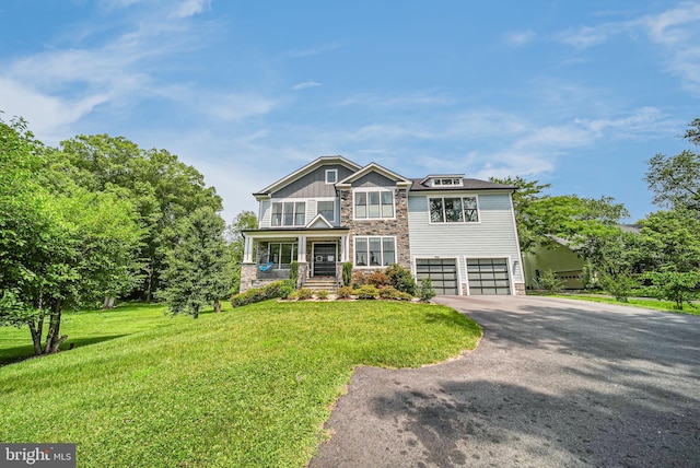 9908 Blake Ln, Oakton, VA 22124 - view of front of property with stone siding, driveway, a porch, a front yard, and an attached garage