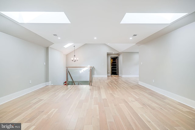 9908 Blake Ln, Oakton, VA 22124 - empty room with a skylight, light wood-type flooring, a chandelier, vaulted ceiling, and recessed lighting
