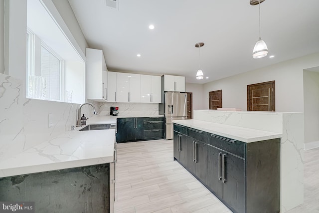 9908 Blake Ln, Oakton, VA 22124 - kitchen with stainless steel fridge, white cabinetry, hanging light fixtures, recessed lighting, and a kitchen island