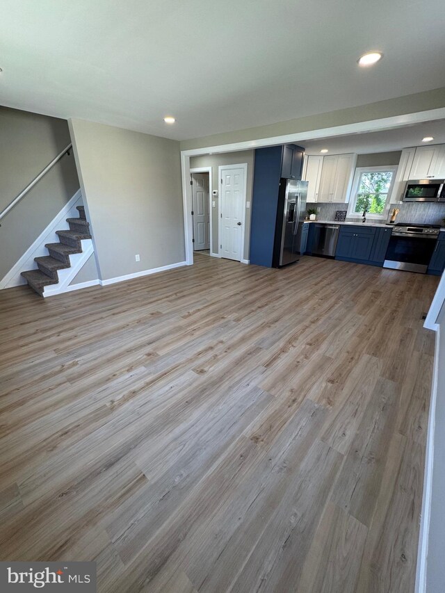 512 Majestic Ave, Bellmawr, NJ 08031 - unfurnished living room featuring recessed lighting, stairway, and light wood finished floors