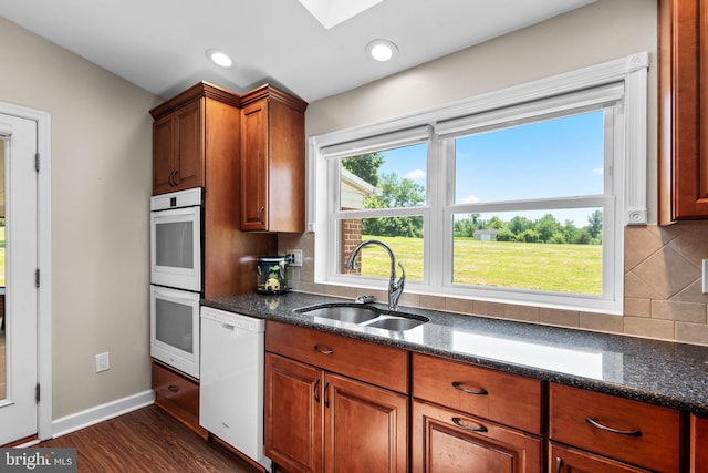 1395 Buckhorn Rd, Sykesville, MD 21784 - kitchen featuring white appliances, a skylight, tasteful backsplash, dark wood-type flooring, and dark stone countertops