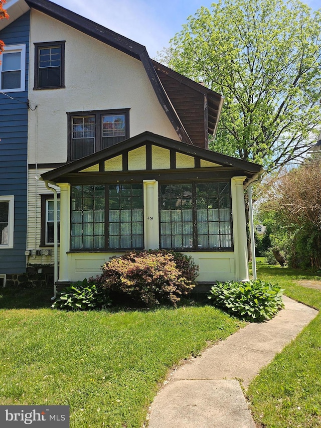 409 W Beechtree Ln, Wayne, PA 19087 - view of front facade featuring a sunroom and a front lawn