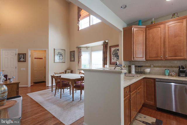 802 Geranium Dr, Warrington, PA 18976 - kitchen with stainless steel dishwasher, a high ceiling, light countertops, decorative backsplash, and wood finished floors