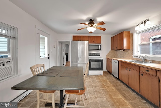 12 Charlestown Rd, Washington Boro, PA 17582 - kitchen with appliances with stainless steel finishes, ceiling fan, light countertops, brown cabinets, and decorative backsplash
