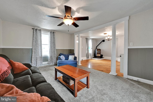 12 Charlestown Rd, Washington Boro, PA 17582 - living area with a wood stove, carpet floors, ornate columns, ceiling fan, and wainscoting