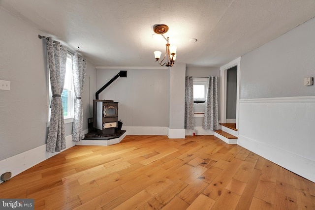 12 Charlestown Rd, Washington Boro, PA 17582 - unfurnished living room featuring a wood stove, wood-type flooring, and a chandelier