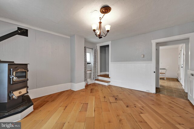 12 Charlestown Rd, Washington Boro, PA 17582 - unfurnished dining area with a wood stove, hardwood / wood-style floors, a chandelier, and crown molding
