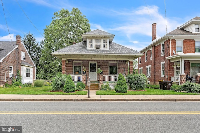 1714 S Main St, Bechtelsville, PA 19505 - view of front facade with brick siding, covered porch, a shingled roof, and cooling unit