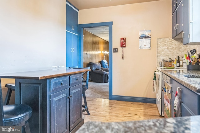 1714 S Main St, Bechtelsville, PA 19505 - kitchen featuring light wood-style floors, tasteful backsplash, a breakfast bar area, and blue cabinetry