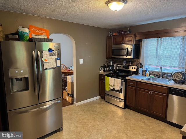 42 Reed St, Mohnton, PA 19540 - kitchen with appliances with stainless steel finishes, arched walkways, a textured ceiling, light countertops, and dark brown cabinetry