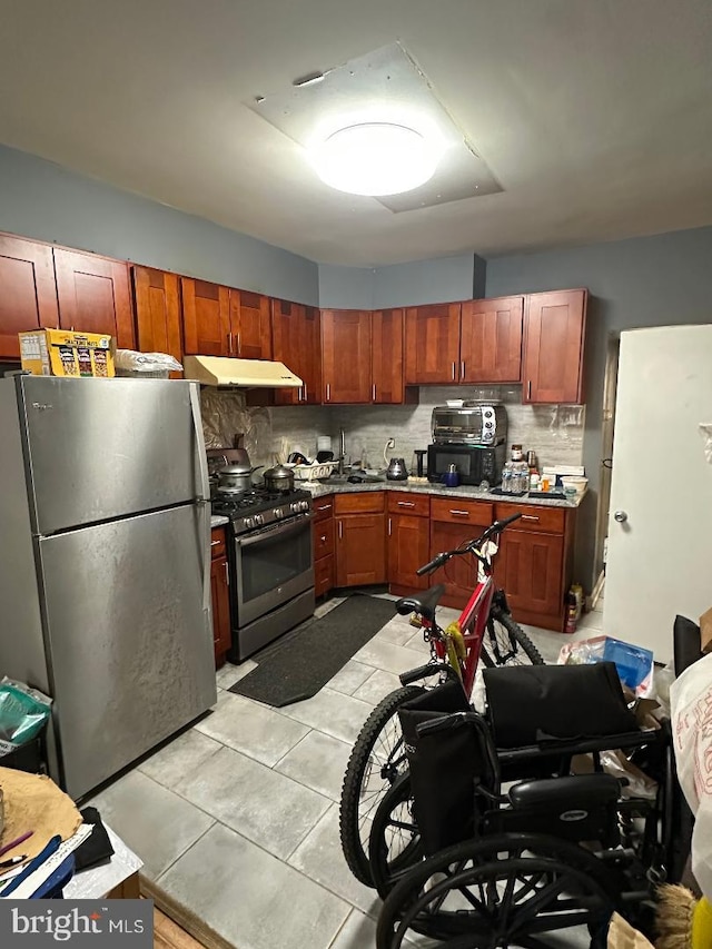 1618 S 6th St, Philadelphia, PA 19148 - kitchen featuring appliances with stainless steel finishes, under cabinet range hood, tasteful backsplash, and light tile patterned floors