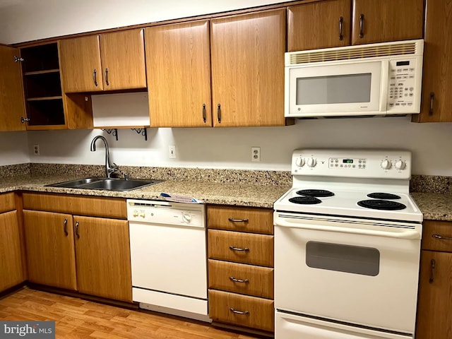 15100 Interlachen Dr Unit 4-701, Silver Spring, MD 20906 - kitchen featuring white appliances, open shelves, light wood-style floors, and brown cabinetry