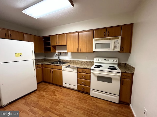 15100 Interlachen Dr Unit 4-701, Silver Spring, MD 20906 - kitchen with white appliances, light wood-type flooring, and brown cabinetry