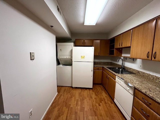 15100 Interlachen Dr Unit 4-701, Silver Spring, MD 20906 - kitchen featuring white appliances, stacked washer and clothes dryer, light wood finished floors, open shelves, and brown cabinetry