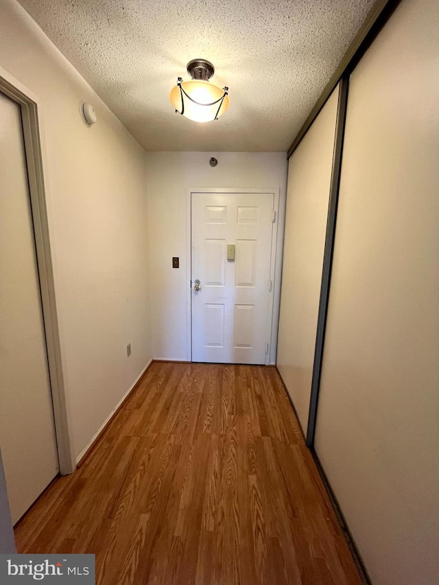 15100 Interlachen Dr Unit 4-701, Silver Spring, MD 20906 - corridor with wood finished floors and a textured ceiling