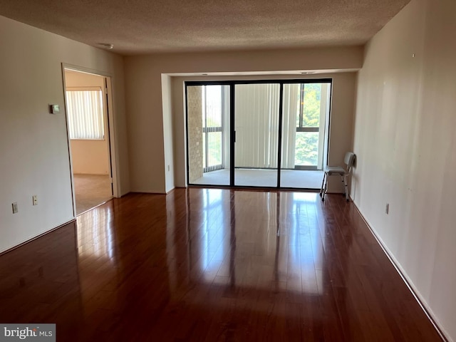 15100 Interlachen Dr Unit 4-701, Silver Spring, MD 20906 - unfurnished room featuring healthy amount of natural light, wood finished floors, and a textured ceiling