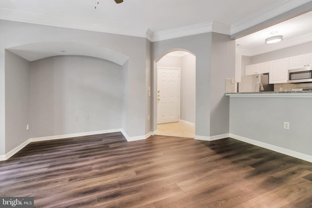 503 Sunset View Ter SE Unit 102, Leesburg, VA 20175 - unfurnished living room with arched walkways, ornamental molding, dark wood-style floors, and a ceiling fan