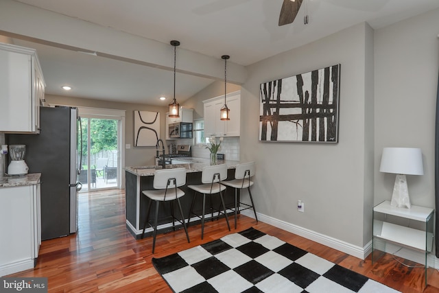 220 Rancocas Rd, Mount Holly, NJ 08060 - kitchen with appliances with stainless steel finishes, white cabinets, wood finished floors, ceiling fan, and a peninsula