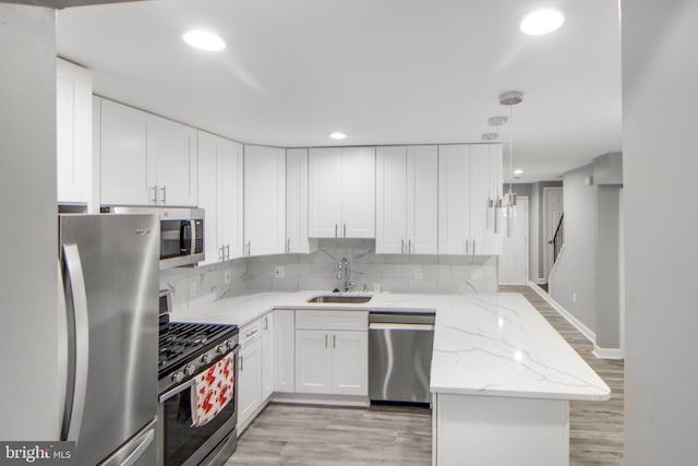 659 Charraway Rd, Baltimore, MD 21229 - kitchen with stainless steel appliances, a peninsula, white cabinets, and recessed lighting