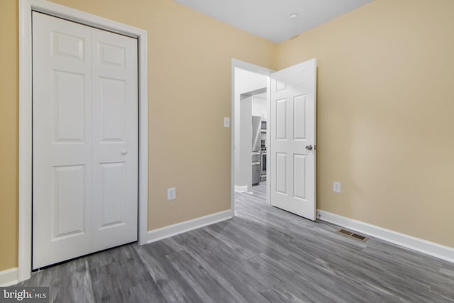 659 Charraway Rd, Baltimore, MD 21229 - unfurnished bedroom with wood finished floors, a closet, and stainless steel refrigerator