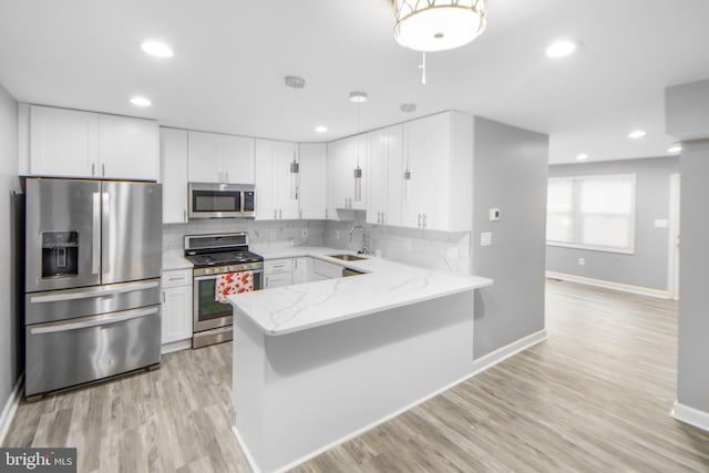 659 Charraway Rd, Baltimore, MD 21229 - kitchen featuring appliances with stainless steel finishes, light stone counters, white cabinetry, recessed lighting, and a peninsula
