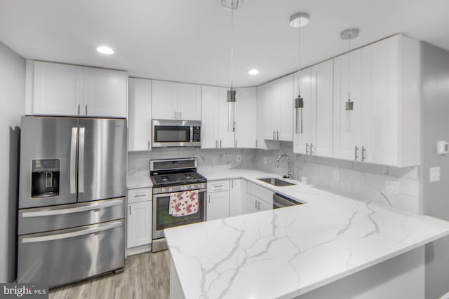 659 Charraway Rd, Baltimore, MD 21229 - kitchen with stainless steel appliances, a peninsula, light stone countertops, white cabinetry, and light wood-style floors