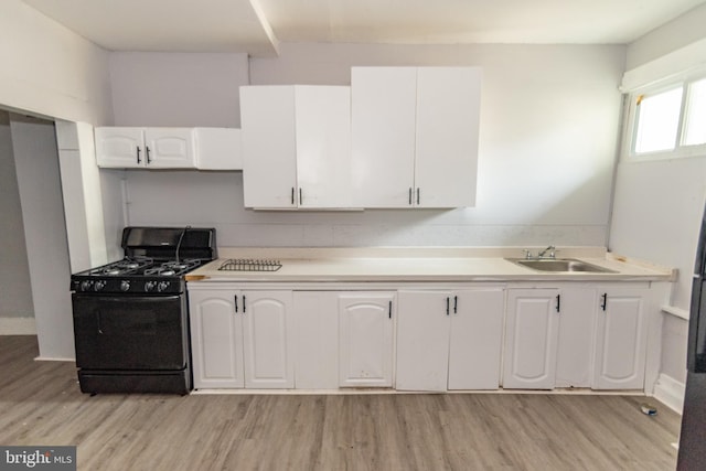 1826 E 28th St, Baltimore, MD 21218 - kitchen with gas stove, white cabinets, light wood finished floors, and light countertops
