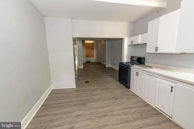 1826 E 28th St, Baltimore, MD 21218 - kitchen featuring black gas stove, white cabinets, light wood-type flooring, and light countertops