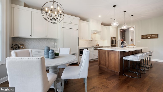 274 W Ashland St, Doylestown, PA 18901 - kitchen featuring a chandelier, an island with sink, dark wood-type flooring, tasteful backsplash, and light countertops