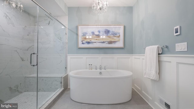 274 W Ashland St, Doylestown, PA 18901 - bathroom with a decorative wall, a freestanding tub, a marble finish shower, a wainscoted wall, and a chandelier