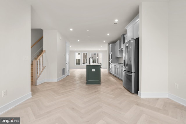 23079 Copper Tree Ter, Ashburn, VA 20148 - kitchen featuring appliances with stainless steel finishes, a kitchen island with sink, recessed lighting, light countertops, and wall chimney exhaust hood
