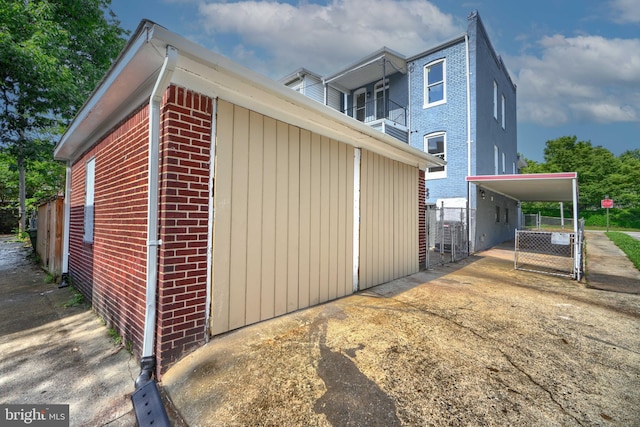 3522 Ellerslie Ave, Baltimore, MD 21218 - view of home's exterior with brick siding, a balcony, concrete driveway, and a carport