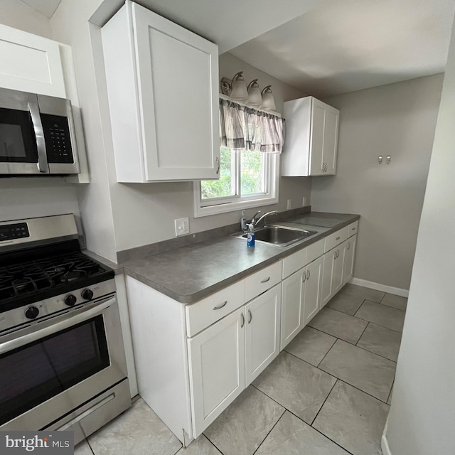 14 Akwaala Trl, Browns Mills, NJ 08015 - kitchen with appliances with stainless steel finishes, white cabinetry, dark countertops, and light tile patterned floors