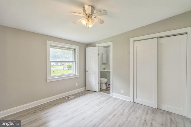 511 Sylvan Way, Pasadena, MD 21122 - unfurnished bedroom with light wood-style flooring, a closet, ensuite bath, lofted ceiling, and ceiling fan