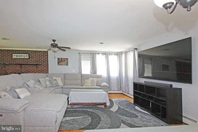 311 Norman Dr, Newark, DE 19702 - living area featuring baseboard heating, wood finished floors, ceiling fan, and brick wall