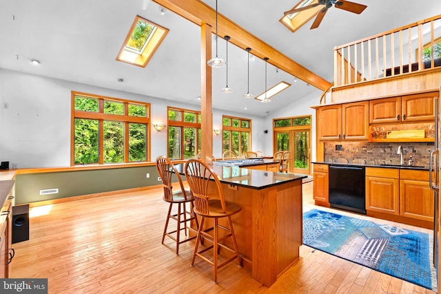 46 Grassy Lake Rd, Shamong, NJ 08088 - kitchen with black dishwasher, a skylight, light wood-type flooring, a breakfast bar area, and dark countertops