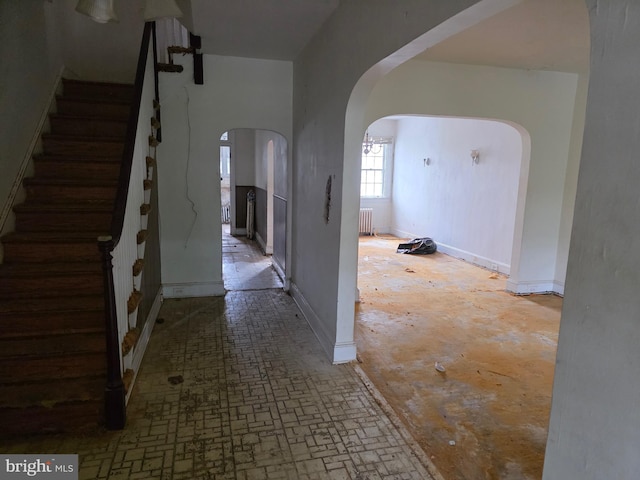 834 N Woodington Rd, Baltimore, MD 21229 - corridor with arched walkways, radiator heating unit, and stairs