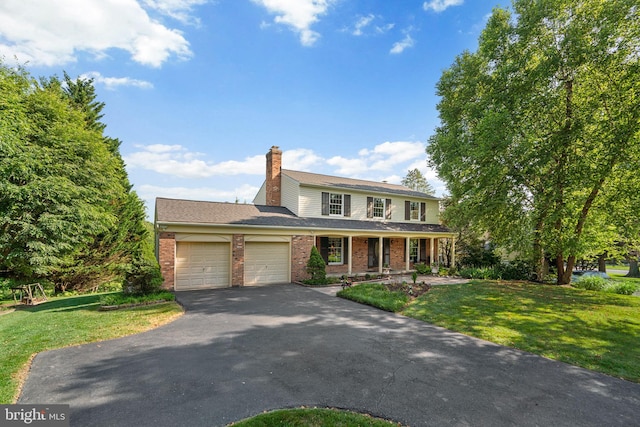 3773 Plum Hill Ct, Ellicott City, MD 21042 - traditional-style home with asphalt driveway, a garage, a front yard, a chimney, and brick siding