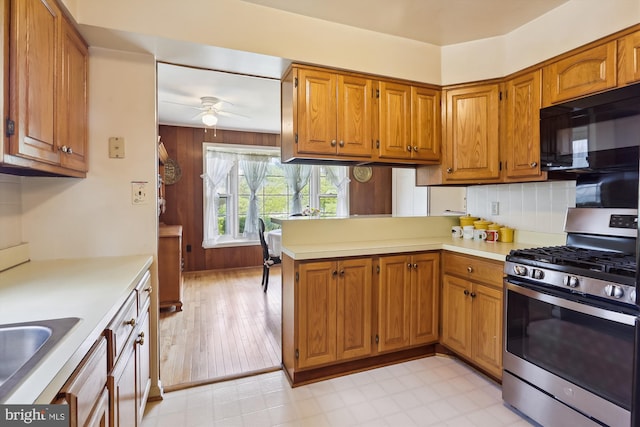 1606 Peacock Ln, Silver Spring, MD 20904 - kitchen featuring stainless steel range with gas stovetop, black microwave, ceiling fan, a peninsula, and light countertops