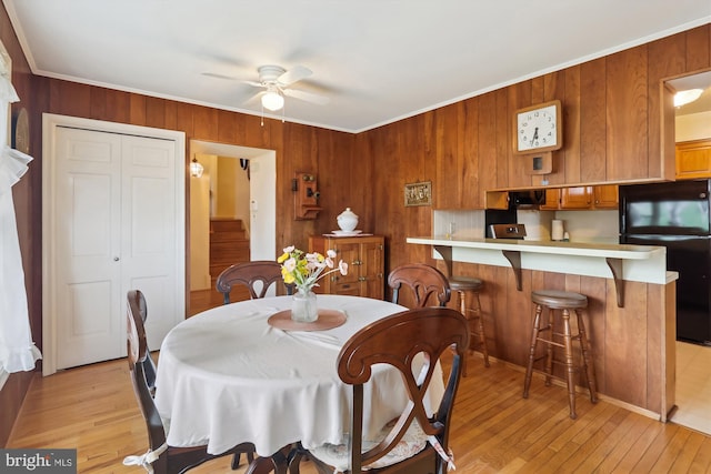 1606 Peacock Ln, Silver Spring, MD 20904 - dining area featuring ceiling fan, ornamental molding, wooden walls, and light wood finished floors
