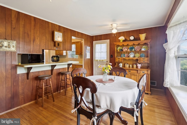 1606 Peacock Ln, Silver Spring, MD 20904 - dining area featuring wood walls, crown molding, a ceiling fan, and light wood finished floors