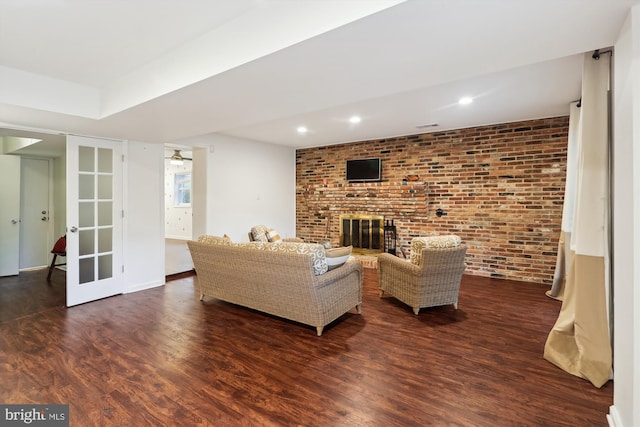 1606 Peacock Ln, Silver Spring, MD 20904 - living room featuring wood finished floors, brick wall, a fireplace, recessed lighting, and french doors