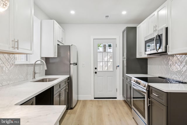 1835 Dudley St, Philadelphia, PA 19145 - kitchen with stainless steel appliances, light wood-style flooring, light stone counters, recessed lighting, and decorative backsplash